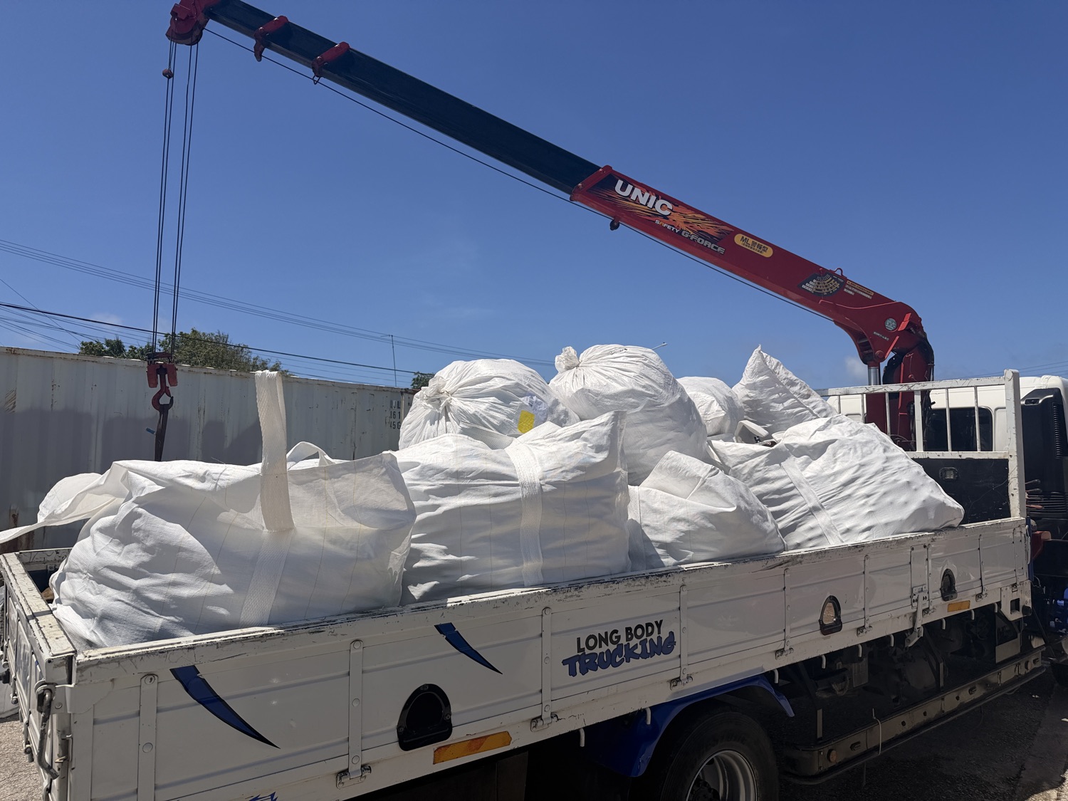 Volle bigbags worden met de kraanwagen opgehaald